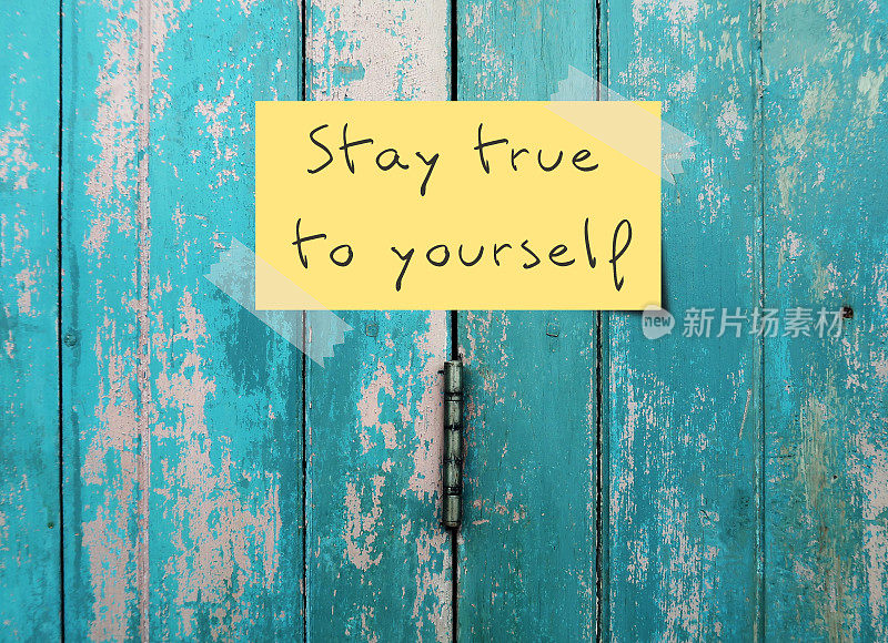 古老的蓝色门背景和手写文字——STAY TRUE TO YOURSELF意味着有自我意识，知道自己的价值观、信仰、偏好，做真正的自己